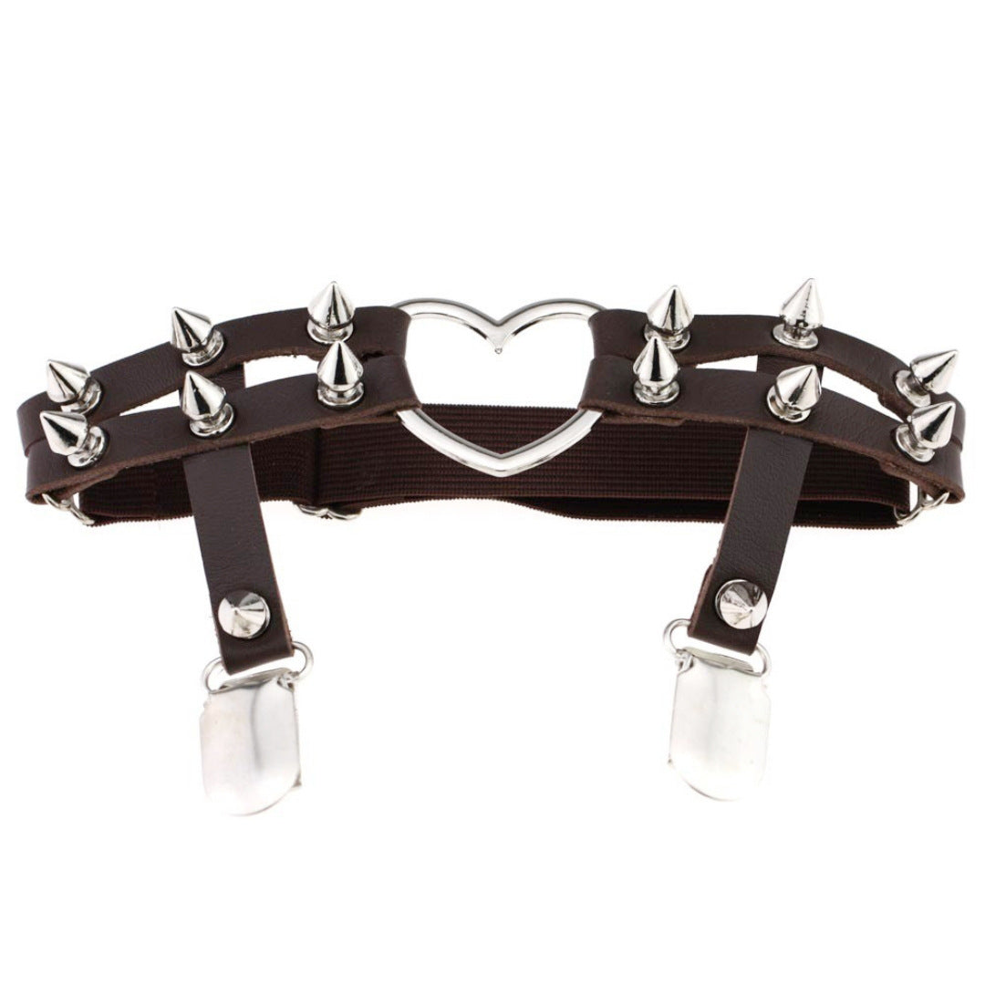Studio product shot of the brown Studded Heart Femboy Thigh Garter photographed from a straight-on angle on a white background, featuring dark brown faux leather straps, silver spike studs, elastic backing, and a polished heart-shaped metal ring, a bold femboy thigh garter for edgy femboy outfit styling.