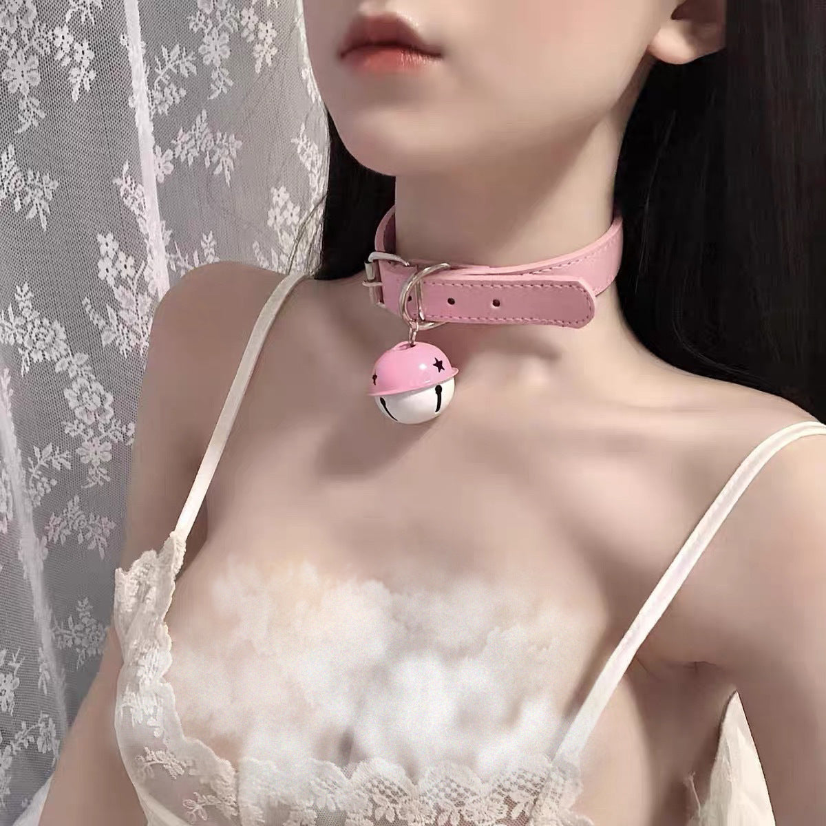 Pink bell collar femboy choker worn on model with white lace lingerie, close-up chest shot showing soft pastel femboy fashion aesthetic
