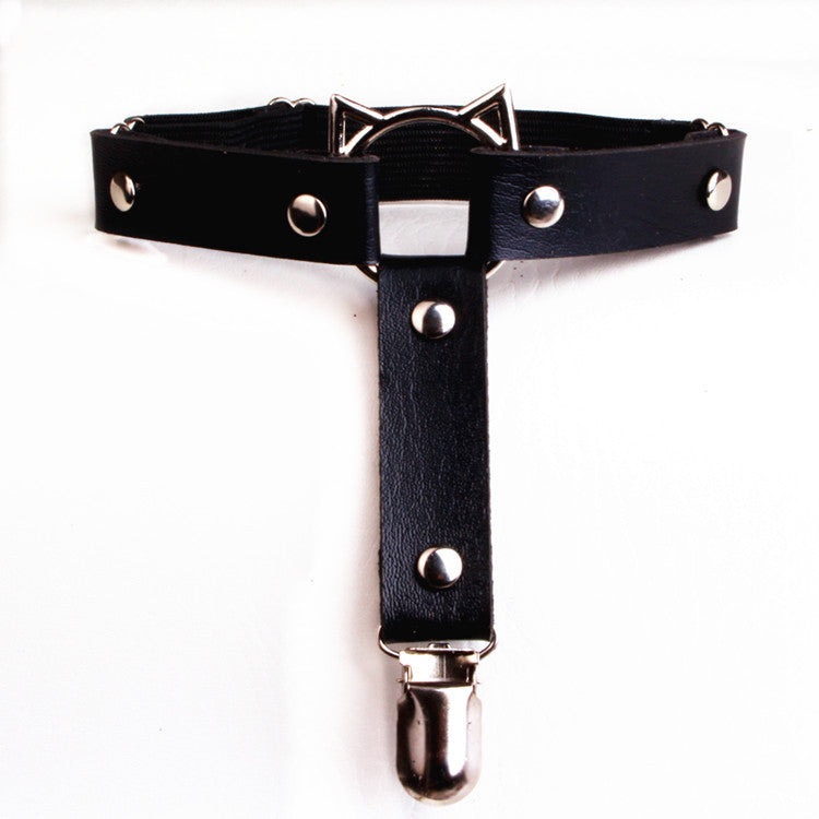 Top-down product shot of the black Cat Face Femboy Thigh Garter photographed from an overhead angle on a white background, showcasing black faux leather straps, silver hardware, elastic backing, and cat face metal detail, a bold and edgy femboy thigh garter for gothic femboy outfit styling.