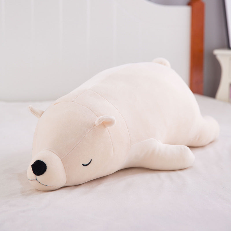 Wide lifestyle product shot of the white Femboy Bear Plushie lying on a bed, captured from a slightly elevated front-facing angle with neutral lighting and a soft white-on-white color palette, emphasizing its minimalist and cozy aesthetic, a cute décor piece often featured alongside femboy clothing online.