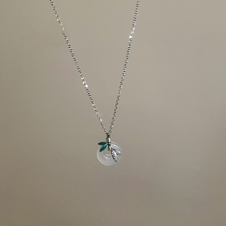 Minimalist silver chain necklace with a clear round crystal and small leaf accents, photographed on a neutral background, perfect for femboy clothing styles.