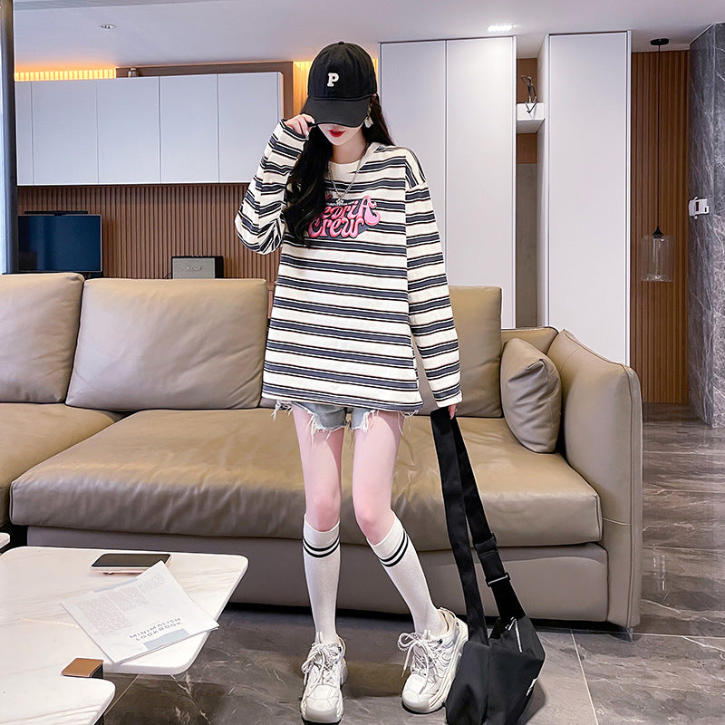 A full-body shot of a model in a long sleeve striped sweatshirt and white knee-high socks, capturing the relaxed and casual vibe of the outfit. A great choice for femboy outfits and everyday wear.