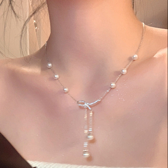 Bow and pearl drop pendant necklace on a model, blending intricate design with chic femboy outfits aesthetic.