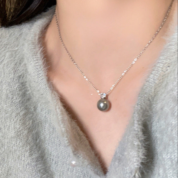 Elegant grey pearl necklace displayed on a neutral-toned sweater, ideal for complementing femboy clothes and accessories.