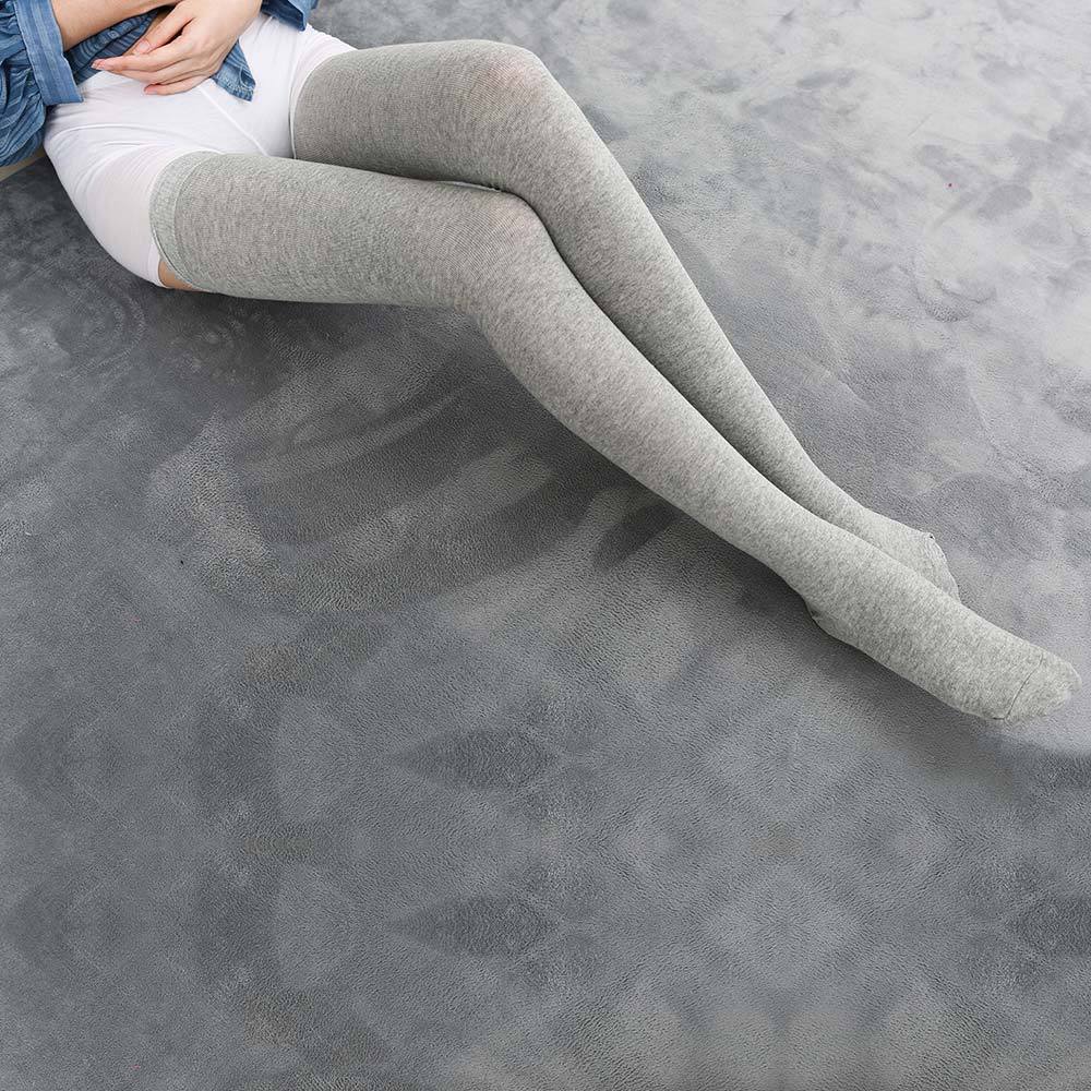 full body seated shot of light grey extra long cotton femboy stockings, displayed on a model with natural relaxed leg positioning, highlighting comfort for femboy clothing styles
