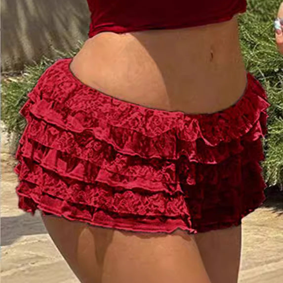 Front view of red tiered lace skirt-pants on a model, showcasing a delicate white lace base with subtle red accents. Captured at eye level in natural light on a neutral backdrop for femboy clothing.