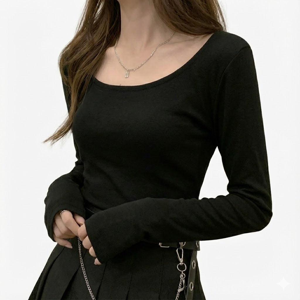 Medium close-up studio shot of a long-sleeve black gothic top styled with a chain belt and pleated skirt, clean white background emphasizing minimalist goth femboy fashion and dark alternative femboy clothing