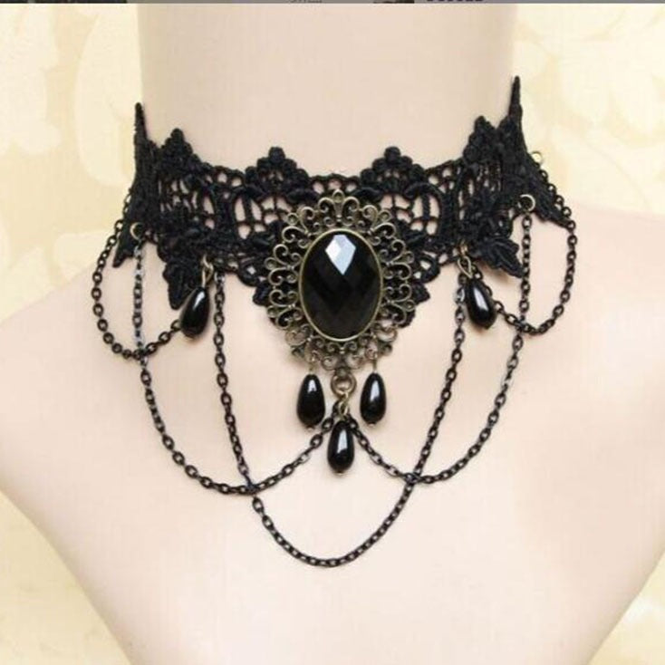 Black gothic lace choker with ornate lace pattern, bold gemstone centerpiece and layered chain drapes, edgy femboy accessory