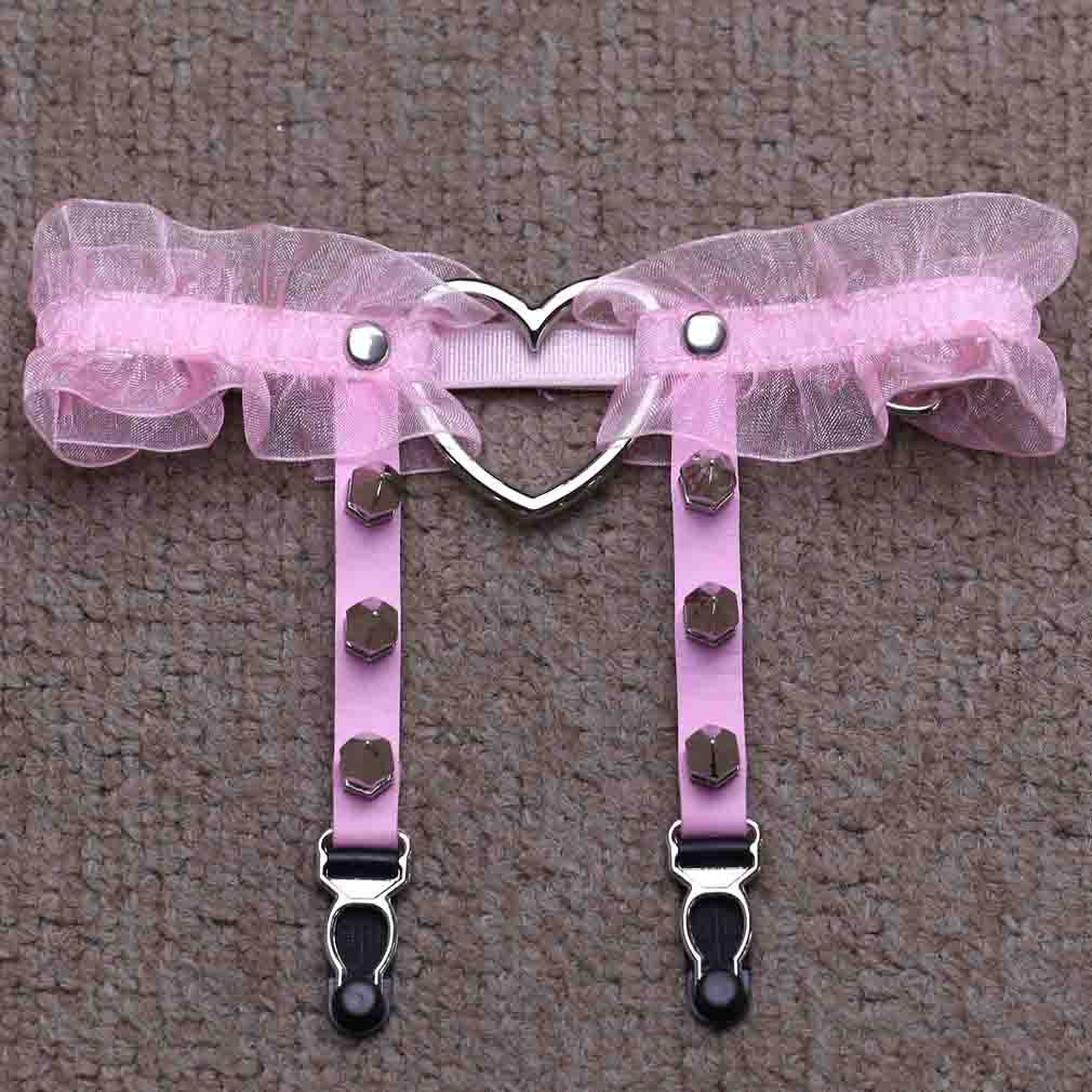 Top-down flat lay of the pink Heart Lace Femboy Garter captured from an overhead angle, highlighting soft pink lace ruffles, adjustable garter straps, and polished heart-shaped metal detail, a cute femboy accessory ideal for pastel femboy outfit and femboy clothing styling.