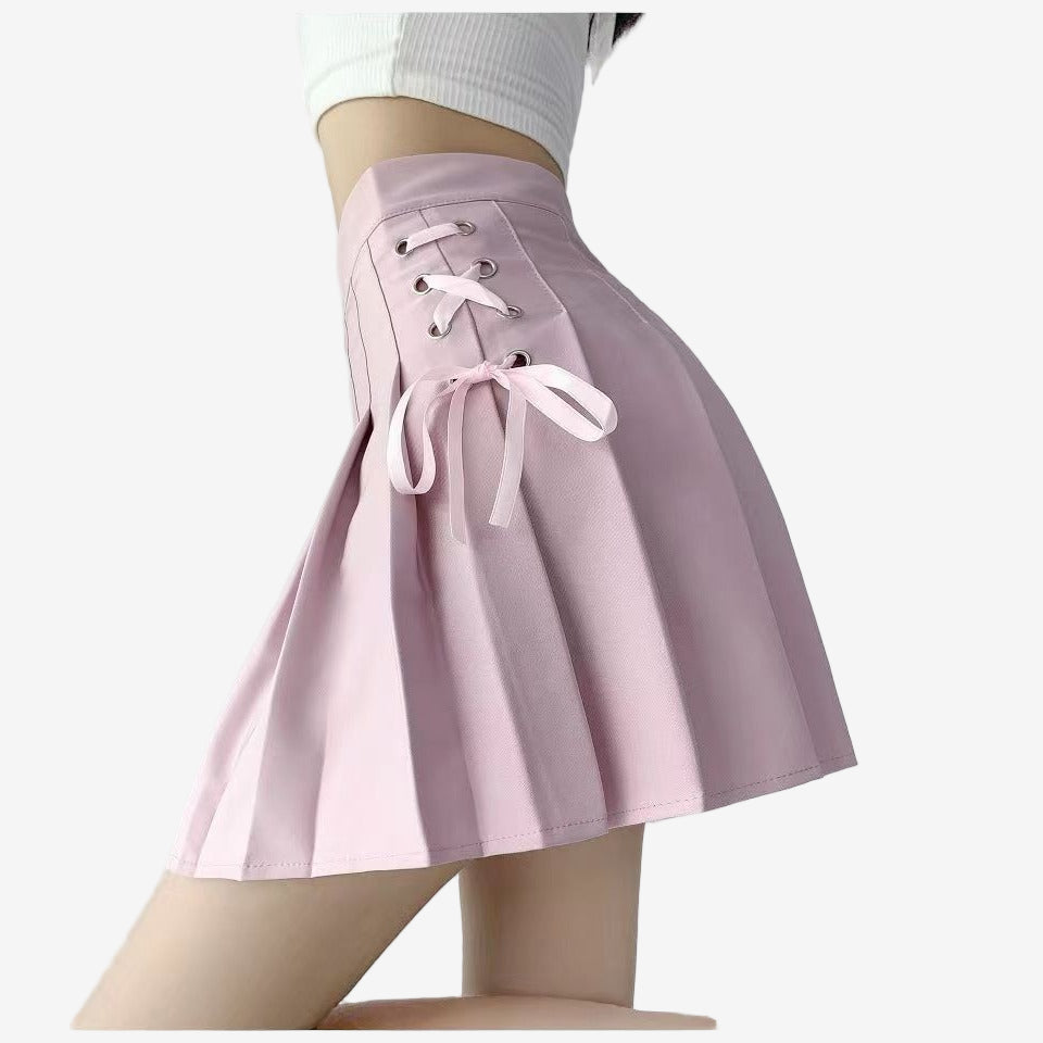 Pink Bowknot Lace Plaid Skirt on a model, featuring side lace-up detailing and a clean pleated structure. The soft pink color adds a delicate, feminine touch, perfect for modern femboy fashion.