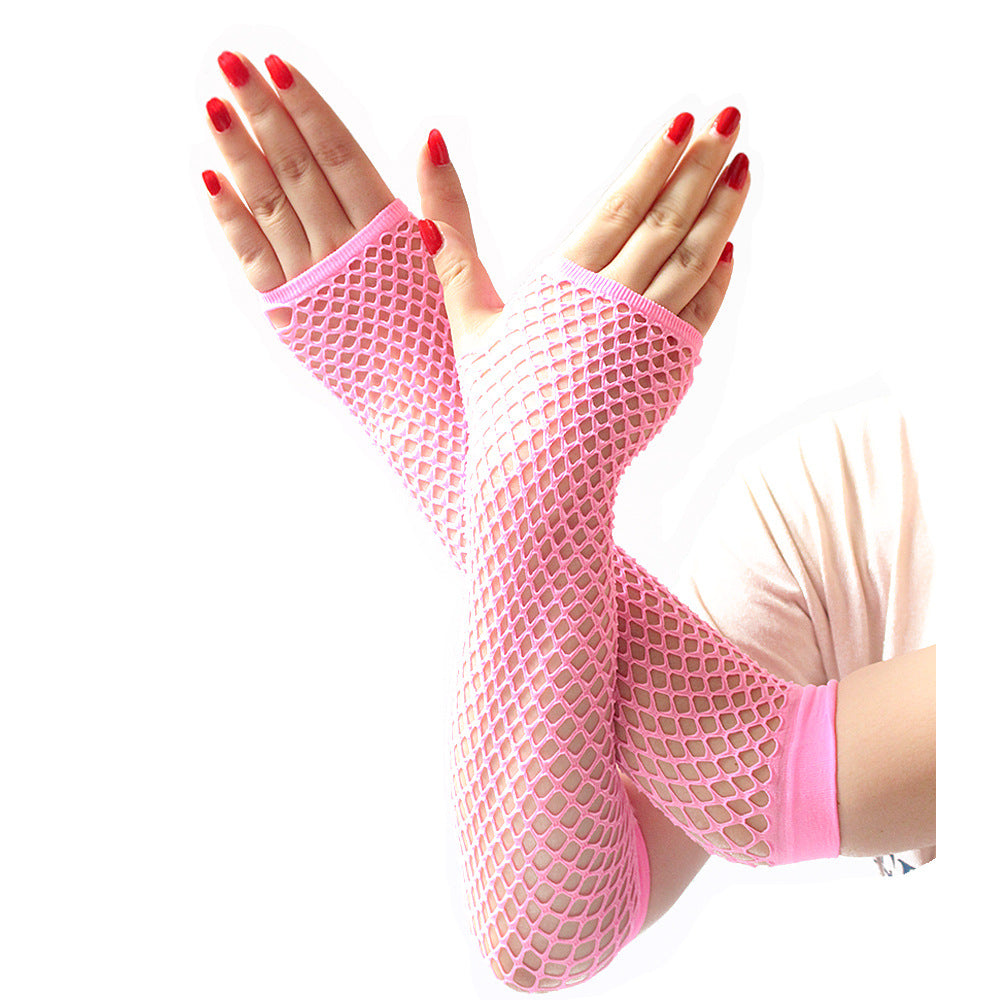 Close-up of pink fishnet arm sleeves worn on crossed hands, showcasing bold mesh texture and bright nail polish, styled for e-girl and femboy fashion outfits.