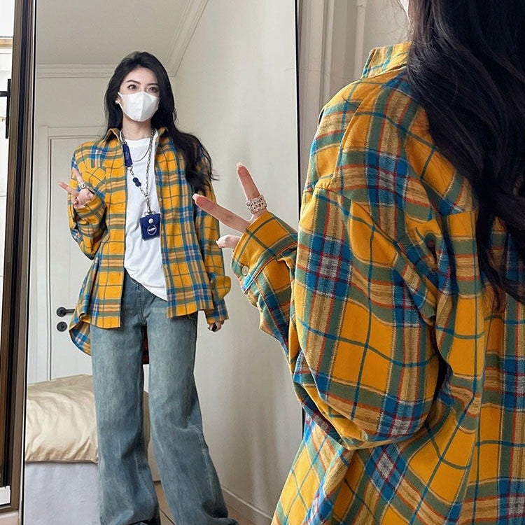 Full-body shot of a model wearing a yellow plaid button-up shirt paired with blue jeans, standing in front of a mirror. The casual yet bold look showcases femboy clothing for an everyday style.