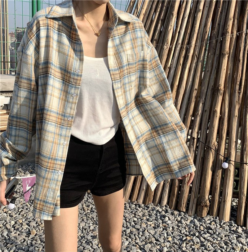 Close-up shot of a plaid button-up shirt in a light blue and yellow pattern worn over a white tank top. The focus is on the shirt’s casual design, perfect for femboy outfits.
