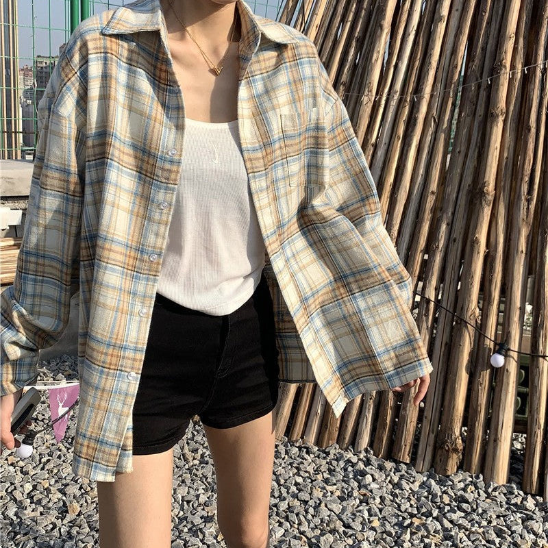 Close-up shot of a plaid button-up shirt in a light blue and yellow pattern worn over a white tank top. The focus is on the shirt’s casual design, perfect for femboy outfits.