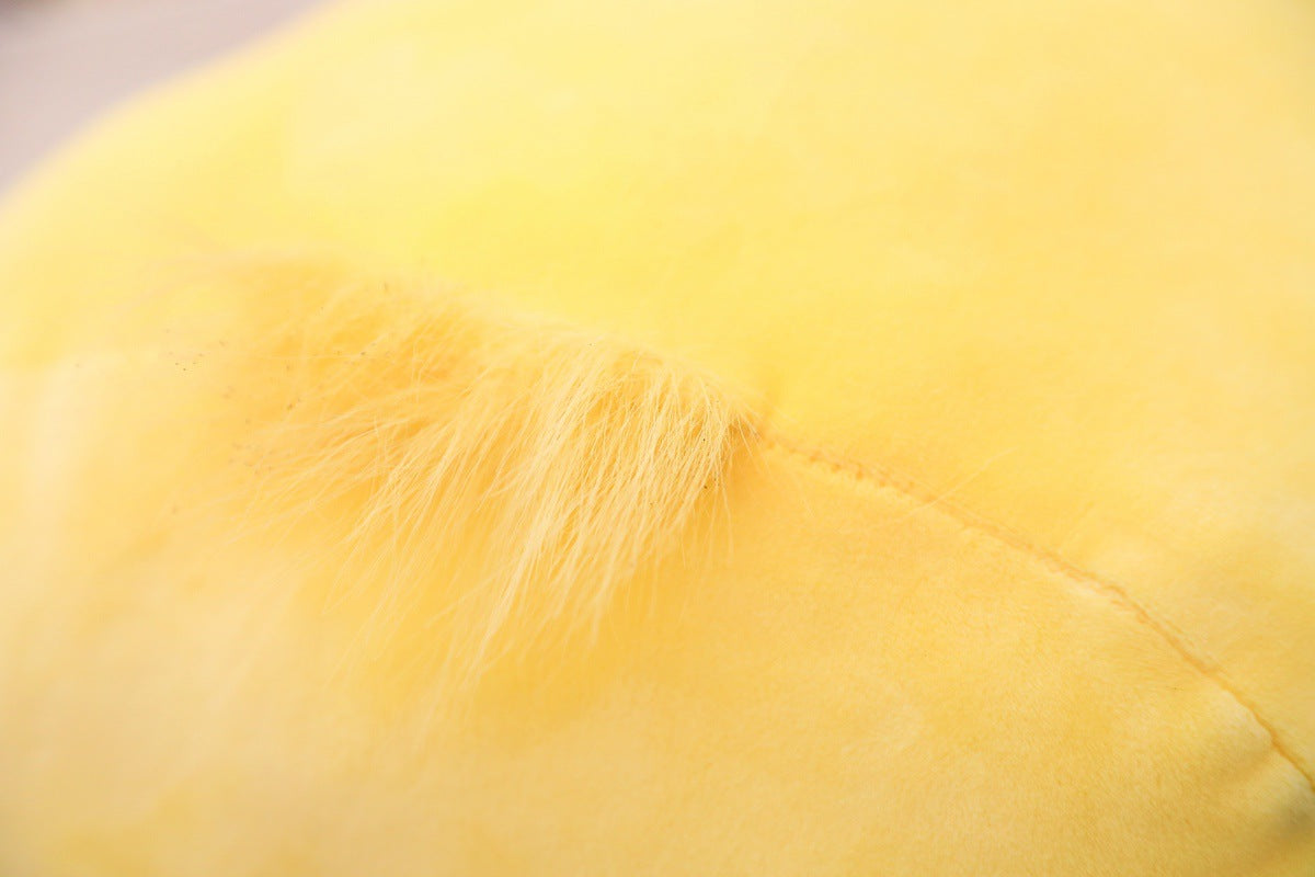 Yellow Soft Duck Plush front-facing close-up on indoor wooden floor, plush toy product shot showing soft fabric texture, rounded body shape, and bright beak detail