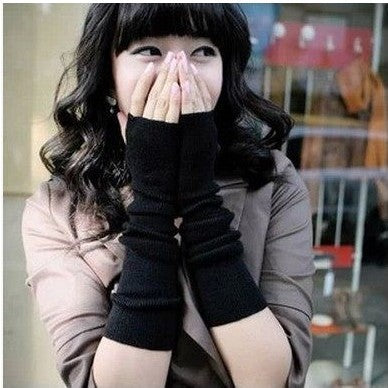 Medium shot of model wearing black fingerless knit gloves, covering arms with a soft knit texture, styled for femboy fashion and cozy femboy clothing. Perfect for winter looks.