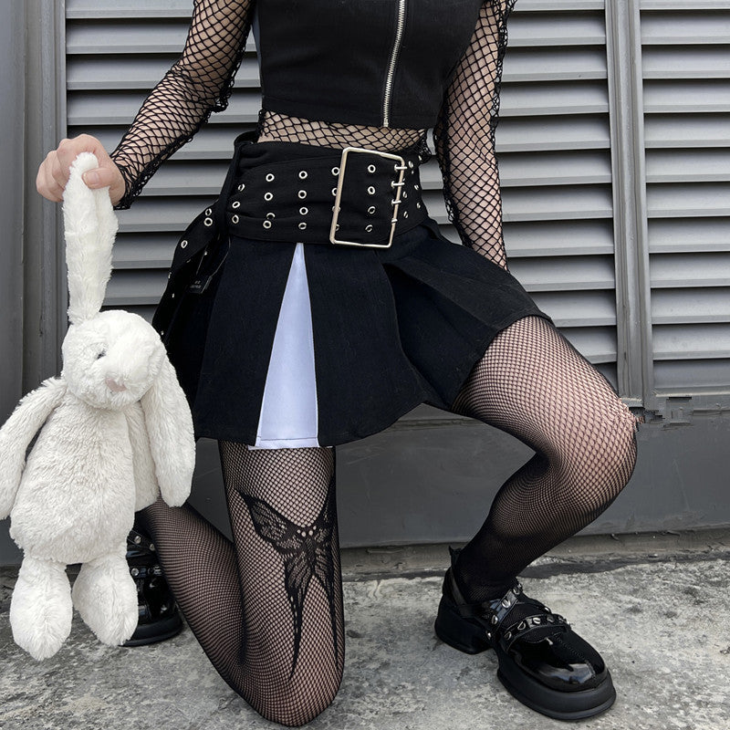 Black gothic bow-knot fishnet tights paired with edgy skirt and mesh top, highlighting bold alternative femboy outfits and gothic fashion styling