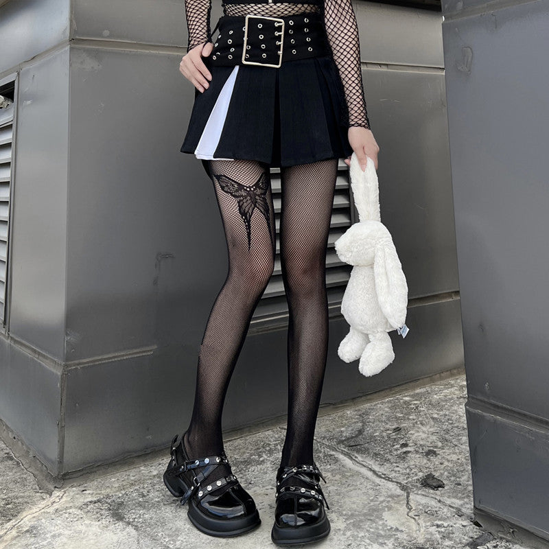 Black gothic bow-knot fishnet tights styled with alternative femboy clothing, showcasing dramatic fishnet texture and rebellious gothic aesthetic