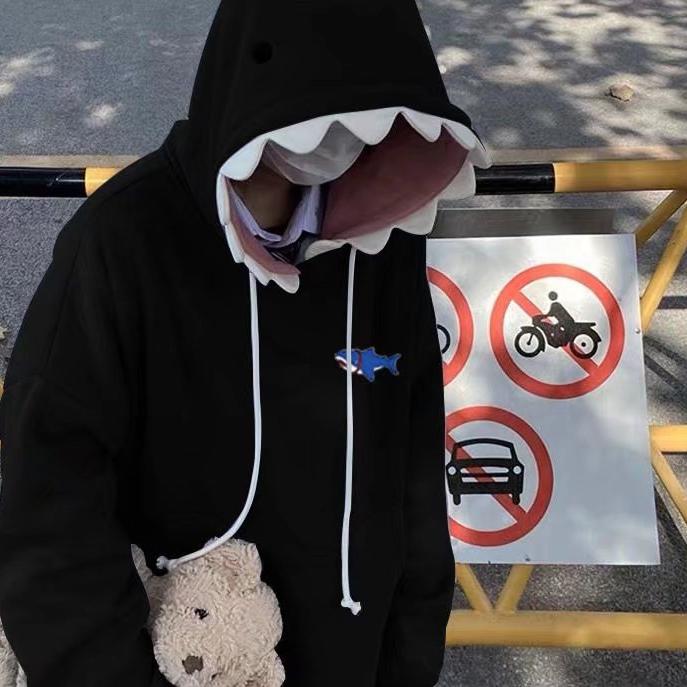 Black shark hoodie worn by a person holding a plush toy, ideal for a comfortable and stylish addition to femboy clothes.