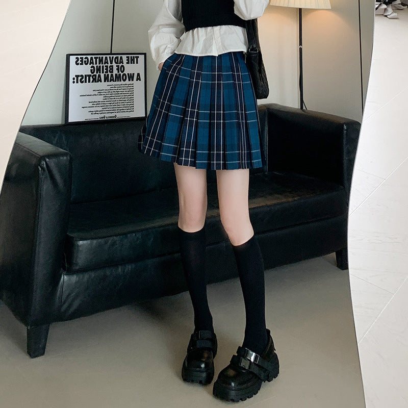 Full-length shot of a blue femboy student skirt styled with a preppy top and black loafers, capturing the school-inspired look that’s popular in femboy fashion circles.