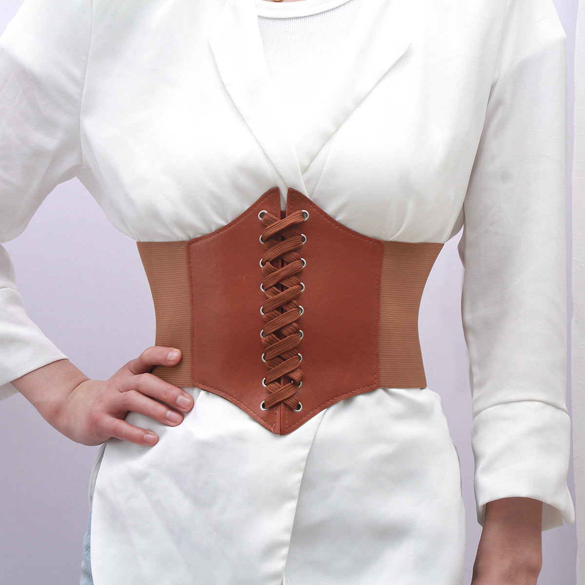 Close-up of a brown corset-style cinch waist belt worn over a white shirt, featuring lace-up detailing for a stylish femboy outfit. Perfect accessory for femboy clothing, adding structure and style.