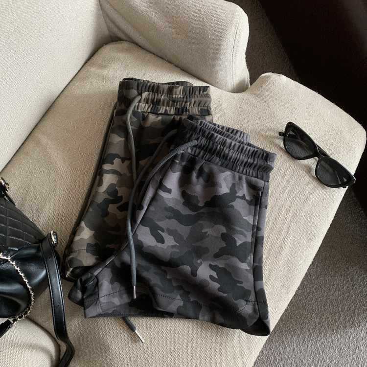 Army green and grey camo print shorts folded, showing knit fabric and drawstring ends