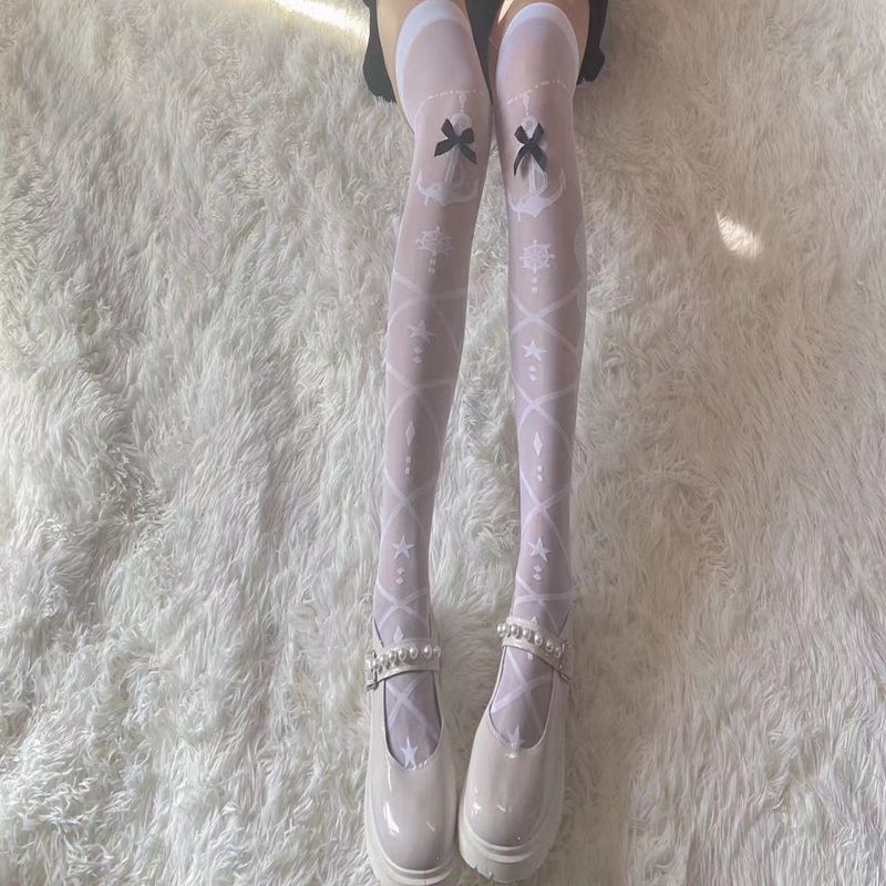 Close-up front view of white Lolita Femboy Thigh Highs with black bows, laid on a soft white carpet background, showcasing delicate lace pattern, perfect for femboy clothing and femboy outfits.