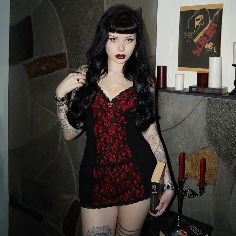  eye-level medium full-body shot of a model wearing a red lace splice cami and matching black mini skirt, holding a gothic novel against a grey stone wall and candlelit mantel, showcasing edgy femboy apparel.