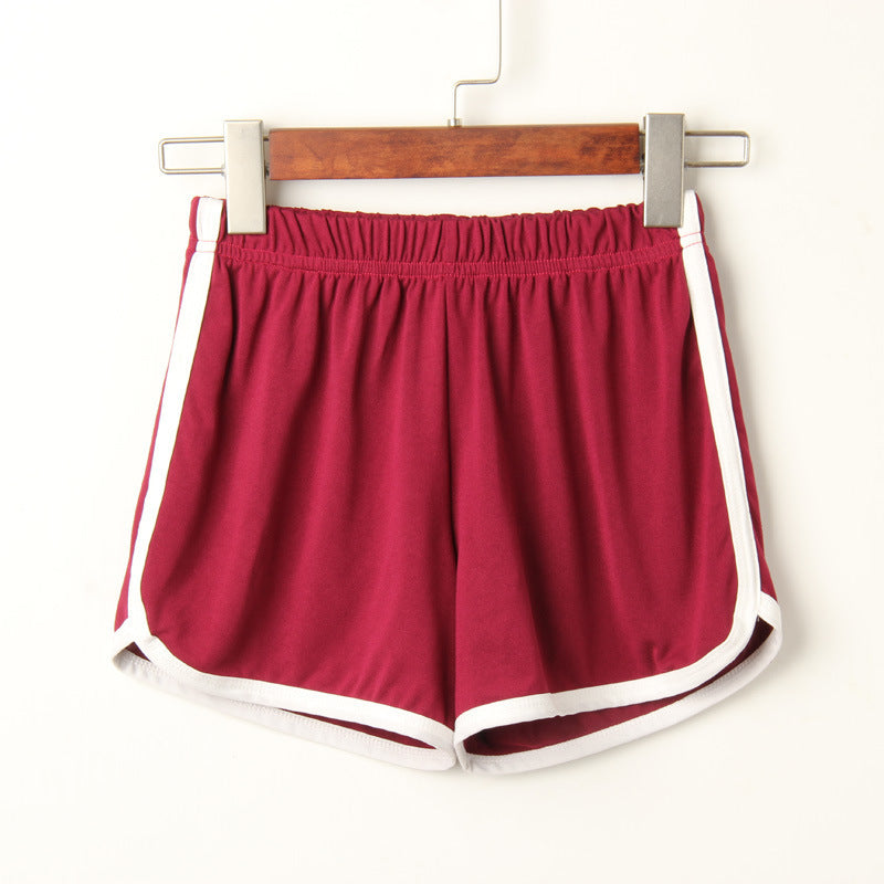 Close-up of dark red Dolphin Shorts with a white outline, hanging on a wooden hanger against a white background. Great choice for femboy fashion and casual femboy clothing.