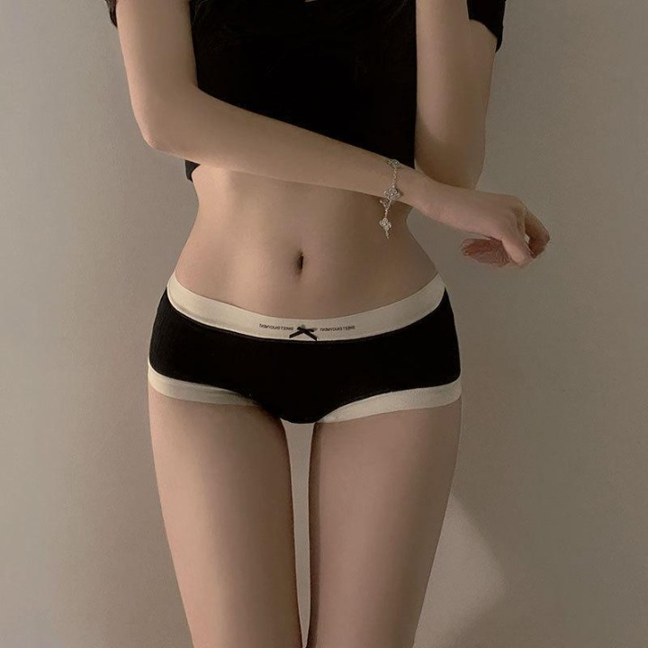 Front view of black modal femboy panties with beige trim, showcasing a snug fit and minimalist design. Perfect for highlighting femboy clothing and fashionable outfits in intimate wear.