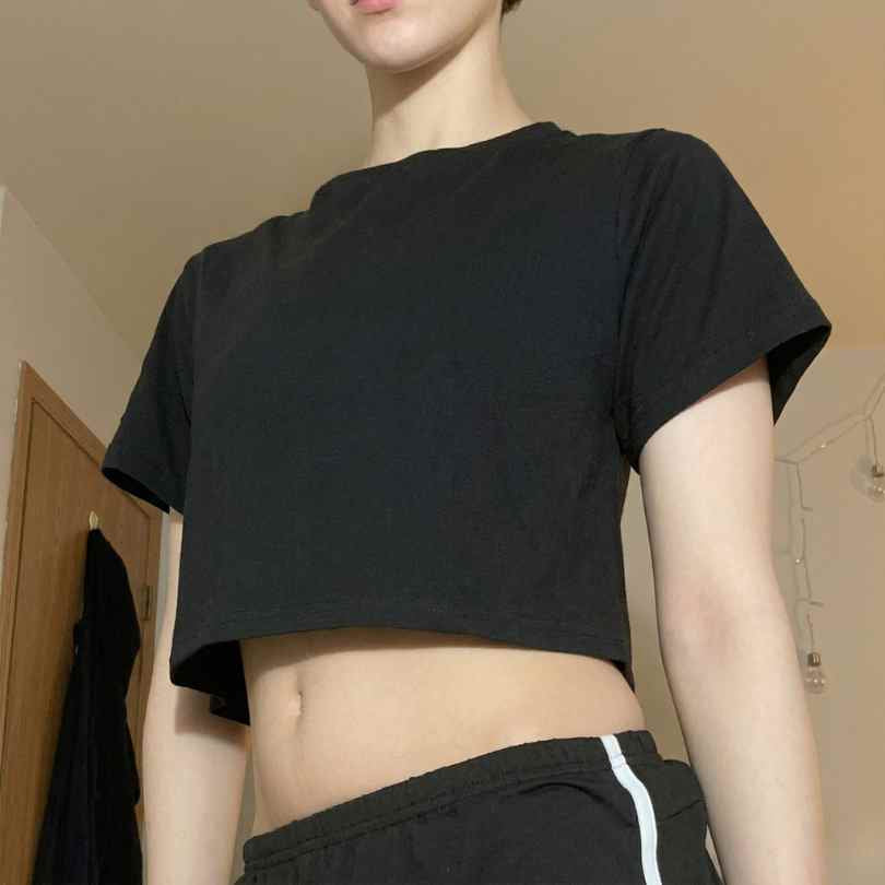 Person wearing the Femboy Starter Pack featuring a black cropped T-shirt and drawstring pants, showcasing modern femboy fashion essentials.