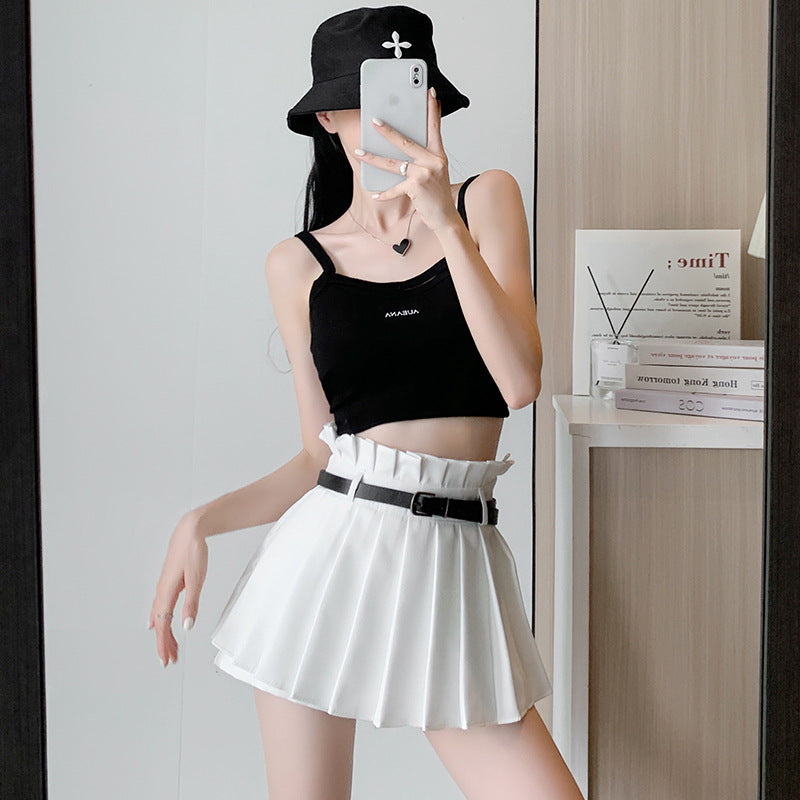 Mirror selfie of a model wearing a white pleated femboy skirt paired with a black crop top, embodying femboy fashion.