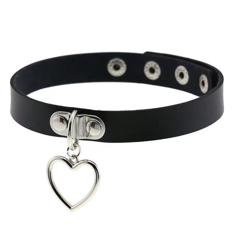 Minimal black femboy gothic choker with silver heart charm, close-up product shot showing sleek faux leather strap and snap button closure, cute gothic femboy accessory for soft and edgy femboy outfits.
