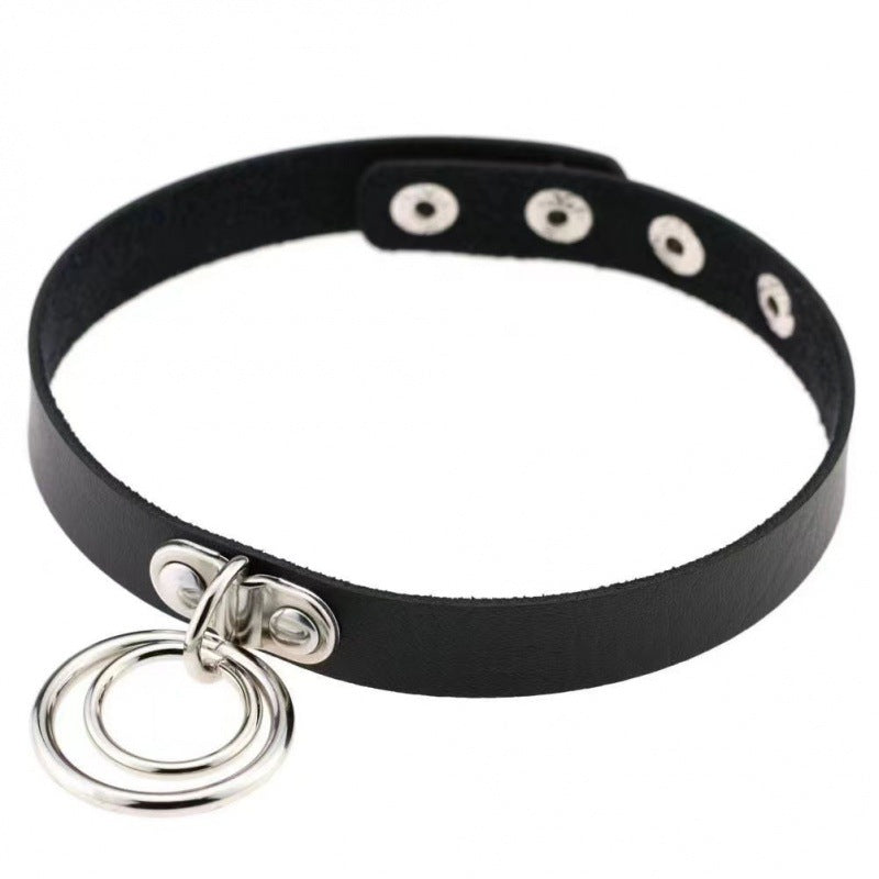 Black faux leather femboy gothic choker featuring a silver double O-ring charm, adjustable snap closure, and minimalist punk design, photographed on a clean white background for femboy fashion styling.