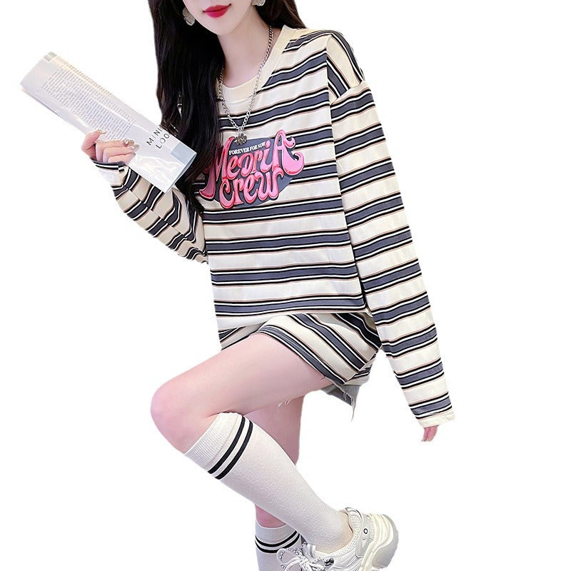 A close-up front view of a model wearing a long sleeve striped sweatshirt with bold black and white stripes, paired with knee-high socks and white sneakers. The relaxed fit and bold stripes make it perfect for femboy outfits and casual femboy fashion.