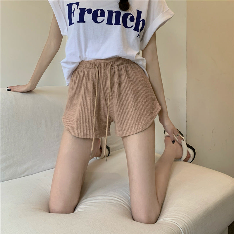 Tan athletic shorts styled with a white French print tee, showcasing a high-waist, loose fit perfect for femboy outfits and casual femboy style.