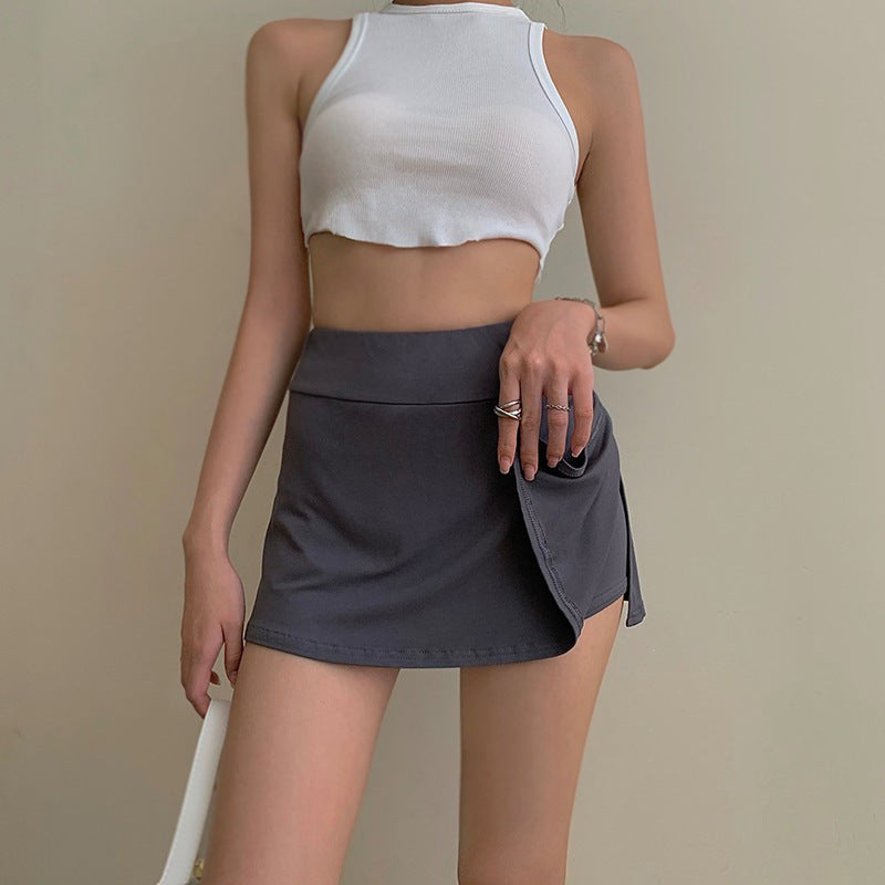 Side view of a model wearing Femboy Tennis Skirt in gray, featuring a high waist and short hem, creating a bold and youthful silhouette. The image focuses on the pleated design and seamless hem, ideal for femboy fashion.