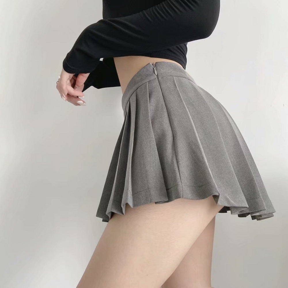 A dynamic swirling shot of a grey Femboy Tennis Skirt on a model, showcasing the fluid movement of the pleats and the snug fit at the waist, against a minimalist backdrop.