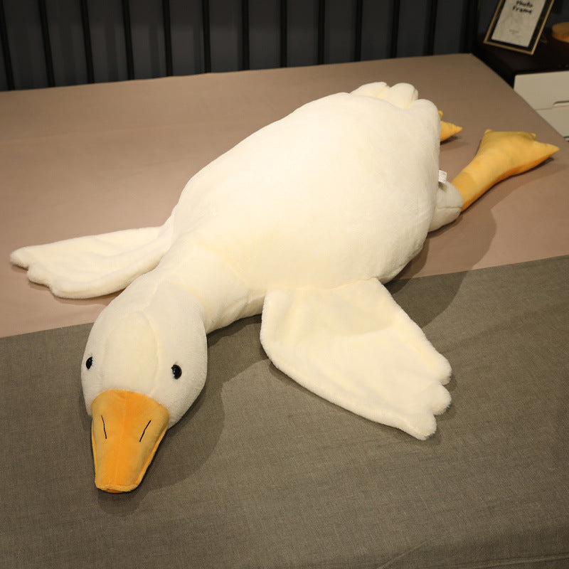 Oversized goose plush body pillow displayed flat on a bed, showing the full shape, smooth stitching, and plush construction for use as a body pillow or decorative cuddle plush.