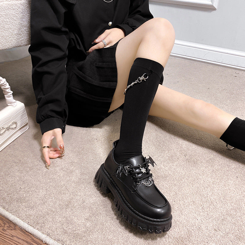 A model wearing black Gothic Lolita School Pumps, complemented by a black outfit and socks, ideal for a femboy outfit that combines gothic and lolita elements for a stylish look.