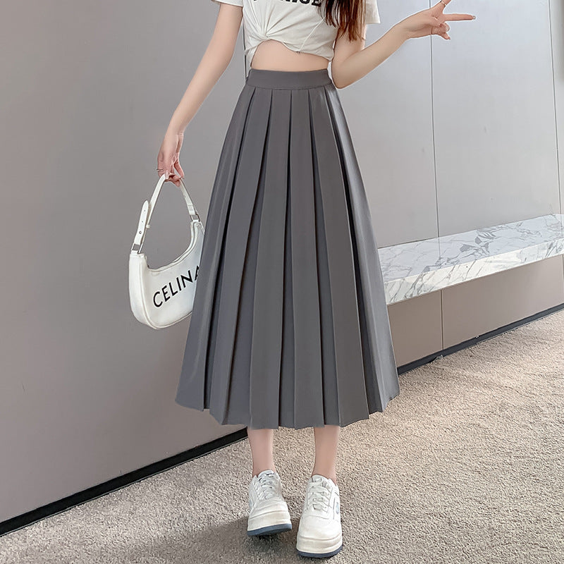 Full-body view of a grey pleated midi skirt, paired with a white graphic tee and white sneakers, showcasing casual femboy clothes and aesthetic, femboy fashion