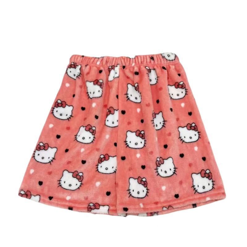 Front flat lay of coral-pink plush Hello Kitty print shorts with repeated small Hello Kitty faces and scattered black heart dots; elastic waist; isolated on a white background, cute lounge-style femboy clothes for femboy fashion.
