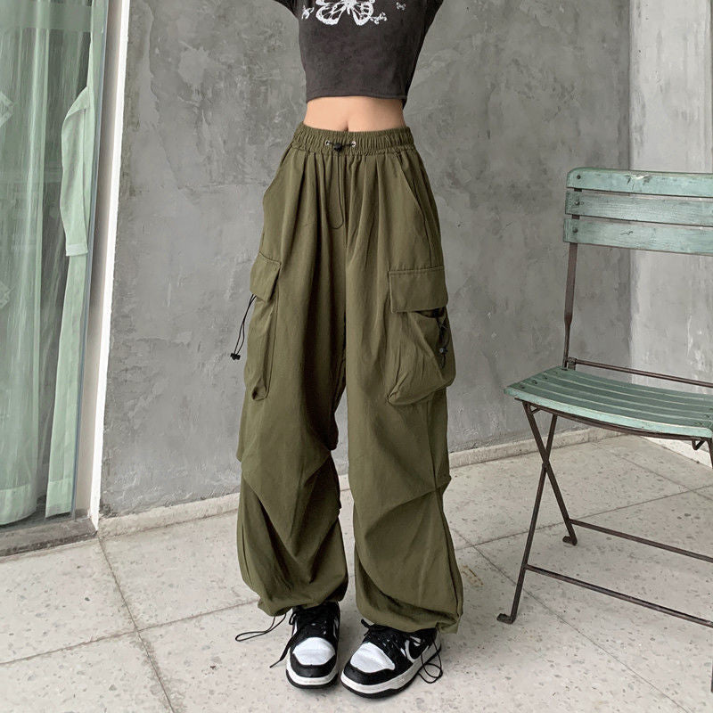 Close-up of olive green high-waisted cargo pants with oversized pockets, showcasing the textured fabric and loose fit, styled with casual sneakers – femboy fashion, gender-neutral cargo pants, stylish utility wear