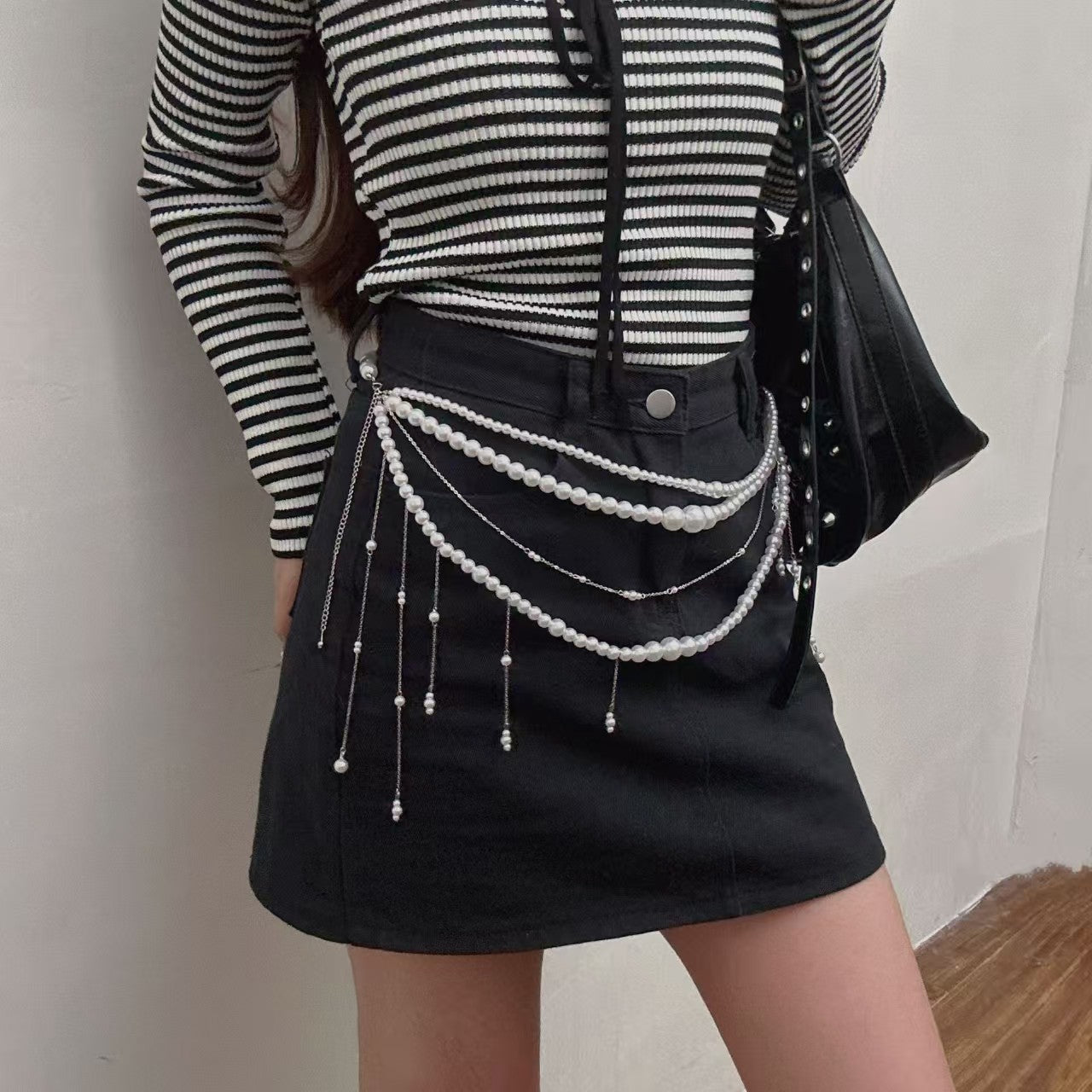  Layered pearl waist body chain styled with stripe top and black skirt, femboy street style accessory