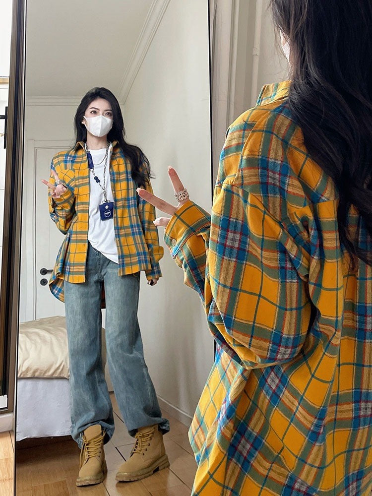 Full-body shot of a model wearing a yellow plaid button-up shirt paired with blue jeans, standing in front of a mirror. The casual yet bold look showcases femboy clothing for an everyday style.