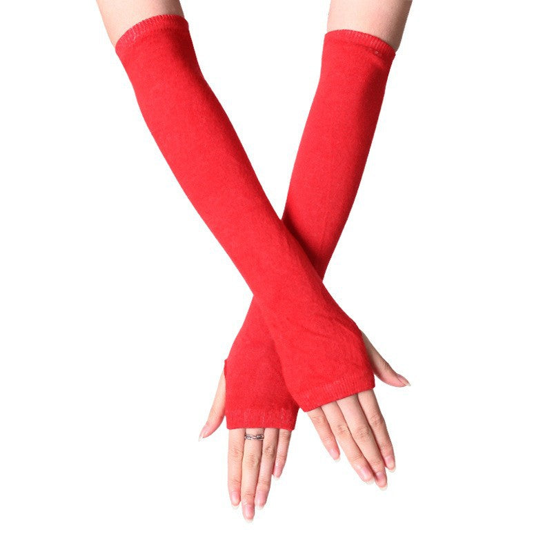 Close-up of hands wearing red fingerless knit arm warmers, ideal for a bold femboy fashion statement. These long gloves are a perfect addition to femboy clothing for winter.