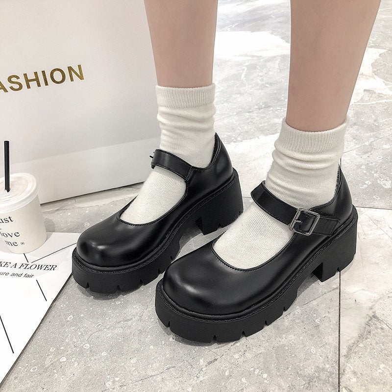 Black school pumps worn with white socks, styled in a trendy indoor setup. A chic addition to femboy clothes and statement footwear.