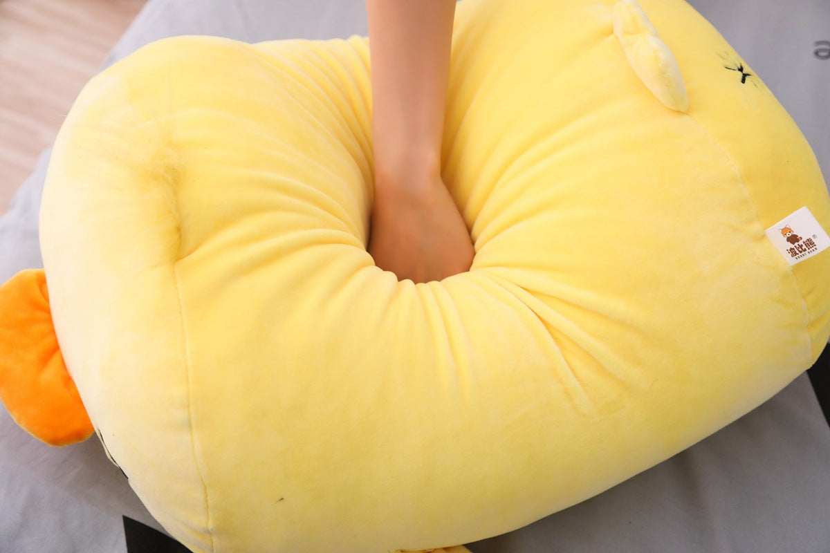 Soft Duck Plush compression test with hand pressing into plush body, close-up product shot demonstrating softness, rebound, and cushion-like filling on indoor surface
