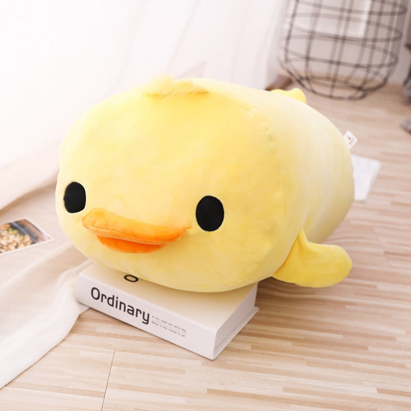 Soft Duck Plush in yellow displayed from a side angle on a wooden floor with soft indoor lighting, emphasizing the smooth plush material, rounded body, and adorable duck face design.