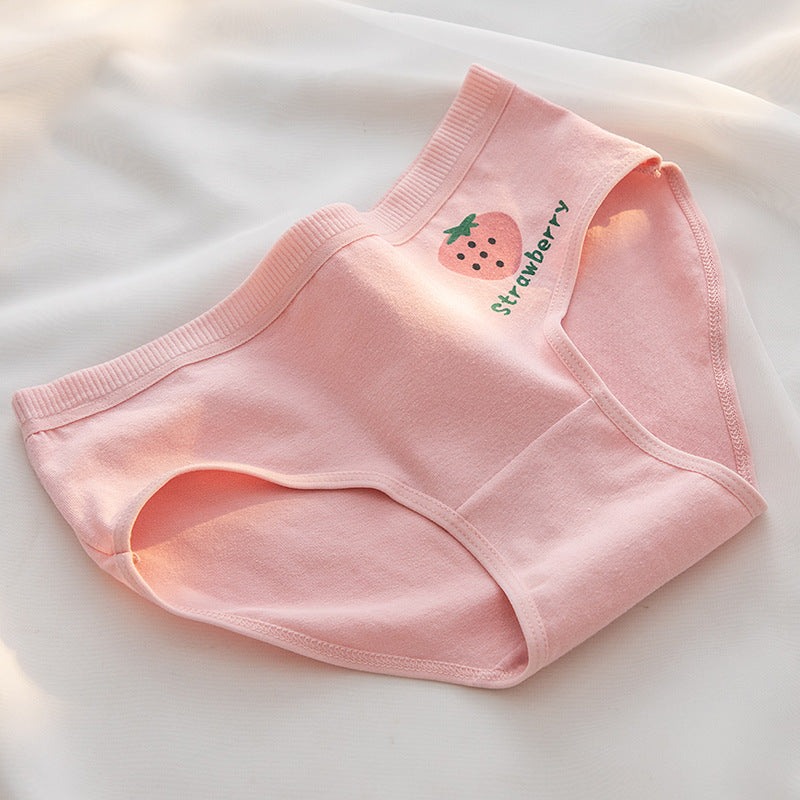 Close-up shot of the back of a pink pair of panties with a single strawberry print and "Strawberry" text. Perfect for femboy clothes collections, these breathable and cute panties are laid out on a white background with natural sunlight filtering in.